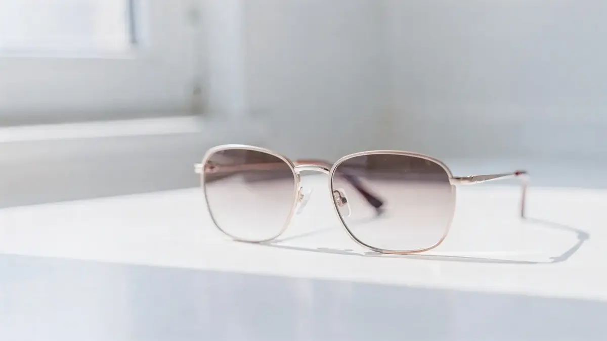 Getönte Sonnenbrille auf hellem Untergrund zum Thema Lichtempfindlichkeit und Sonnenschutz