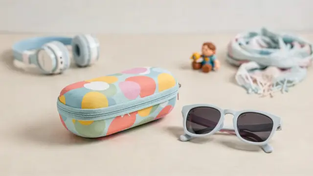 Hartschalenetui für Sonnenbrillen neben Kinder-Sonnenbrille als Schutz für unterwegs