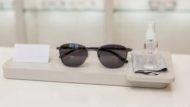 Stylische Sonnenbrille mit UV-Schutz auf hellem Untergrund mit UV-Testkarte