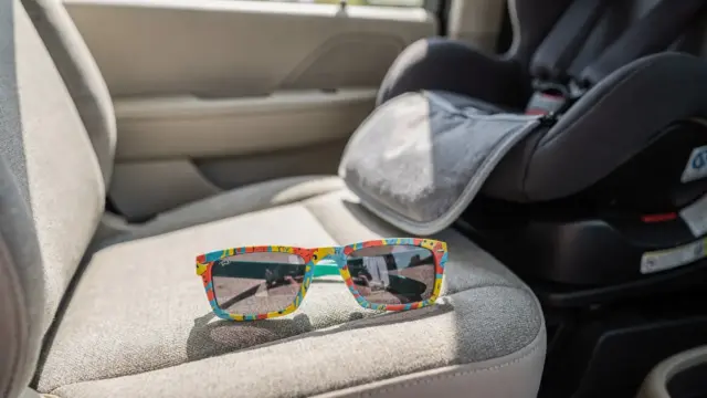 Kindersonnenbrille für die Autofahrt neben Kindersitz und Sonnenschutz im Auto