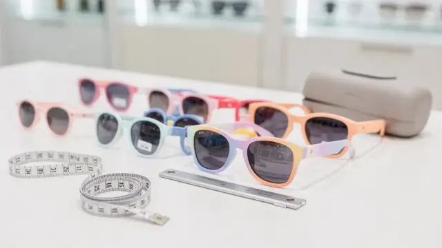 Kindersonnenbrille mit Maßband und Größenangaben in einem Optik-Setting