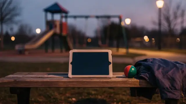 Kind draußen mit Tablet in der Dämmerung – Thema Blaulichtfilter für Kinder